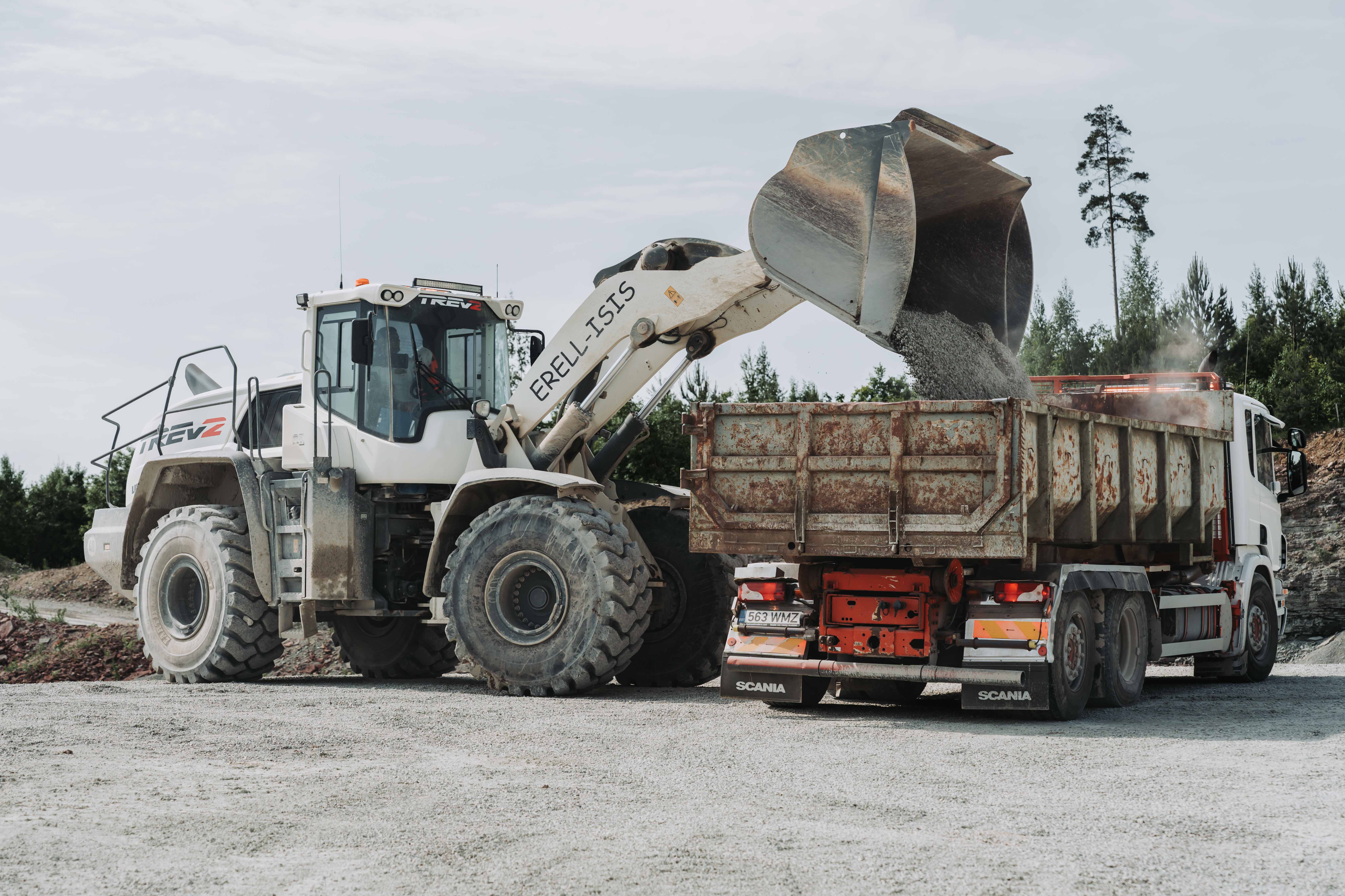 Wheel loader loading gravel into a Scania truck at a quarry